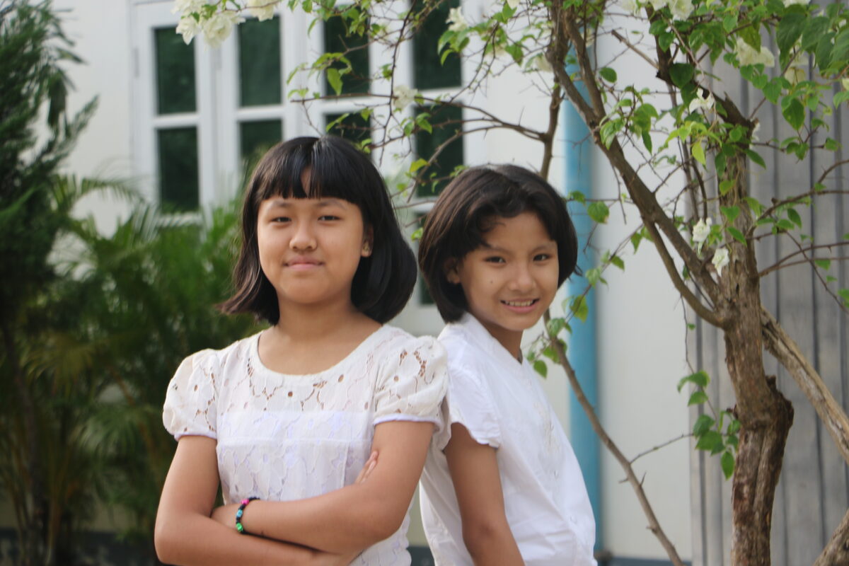 Two young women at Christ Embassy Children's Home, photographed back to back