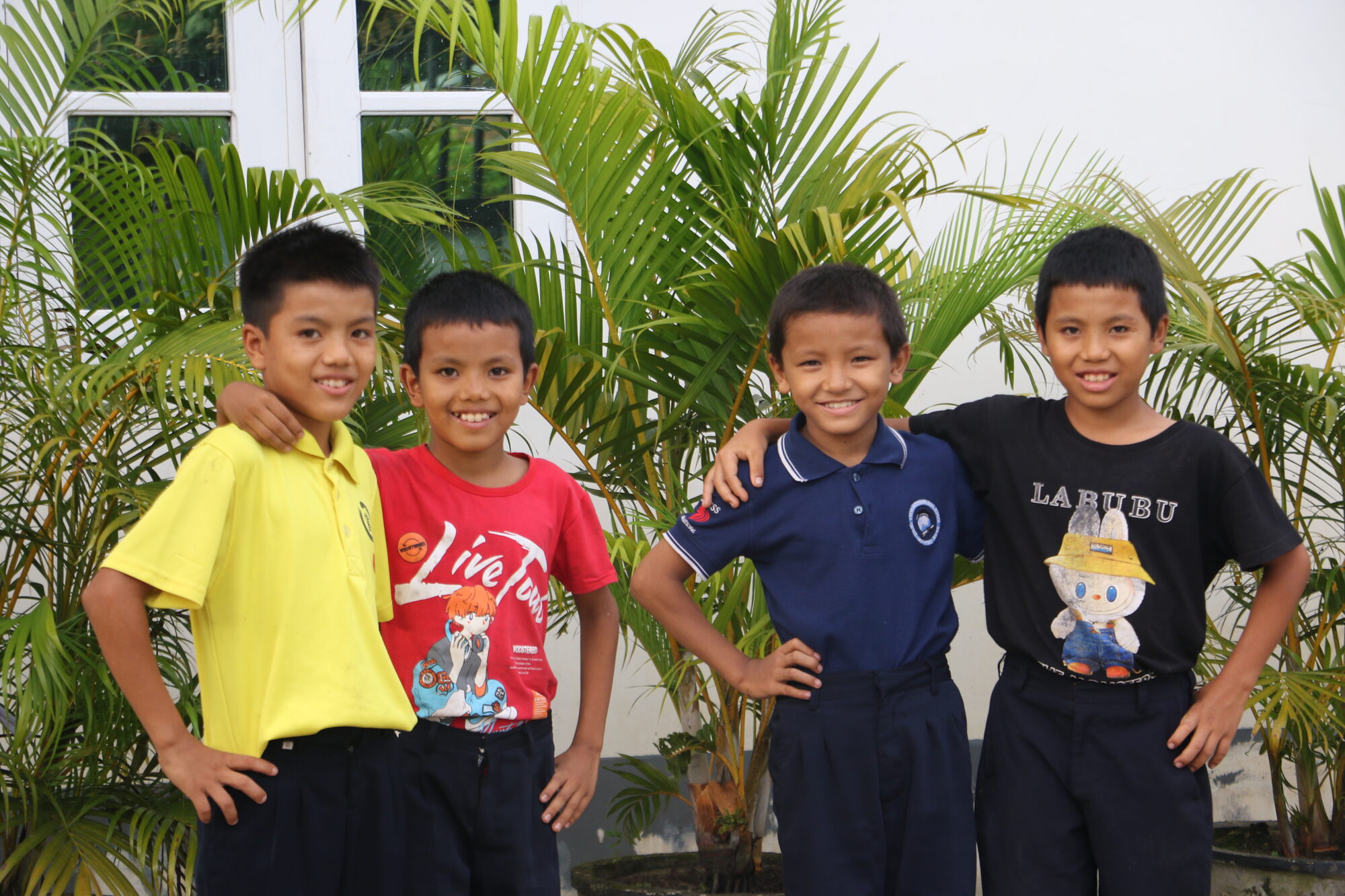 A group of boys at Christ Embassy Children's Home, arms around each other and smiling