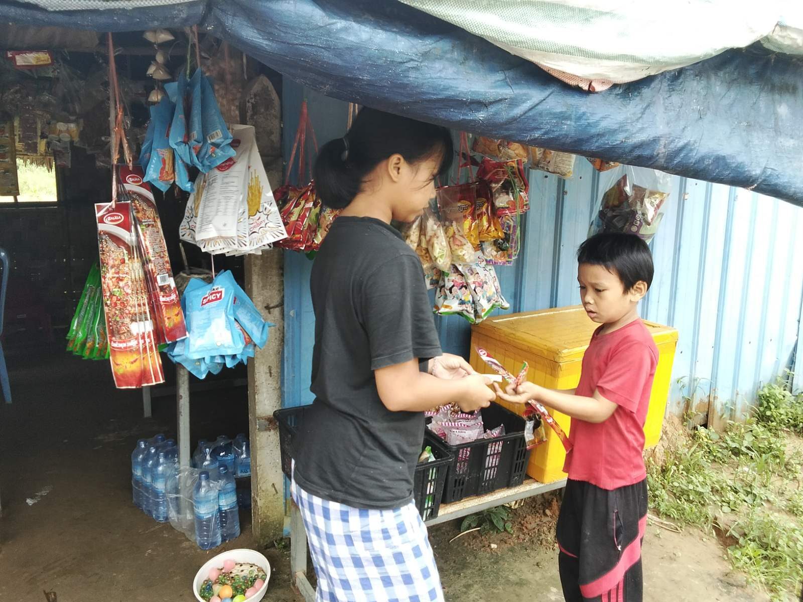 A young woman and a child at a small shop in a Burmese village